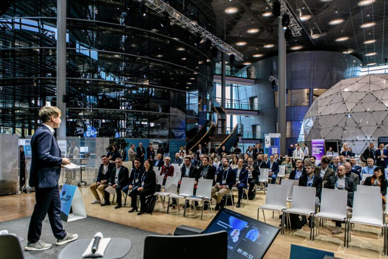 Eventreportage eine Gruppe von Menschen, die in einem Raum auf Stühlen sitzen, während ein Mann spricht